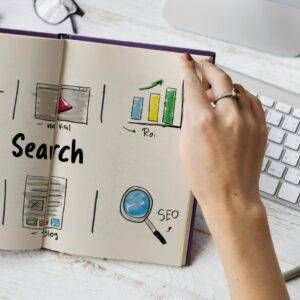 A hand holding a book with the word search written on it.