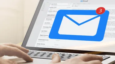 A person using a laptop with an email icon on it.